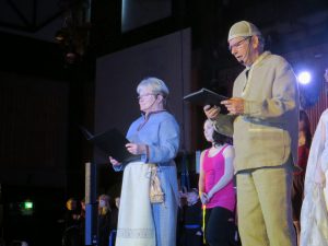 Mies ja nainen vanhanaikaisissa vaatteissa puhuvat juhlassa